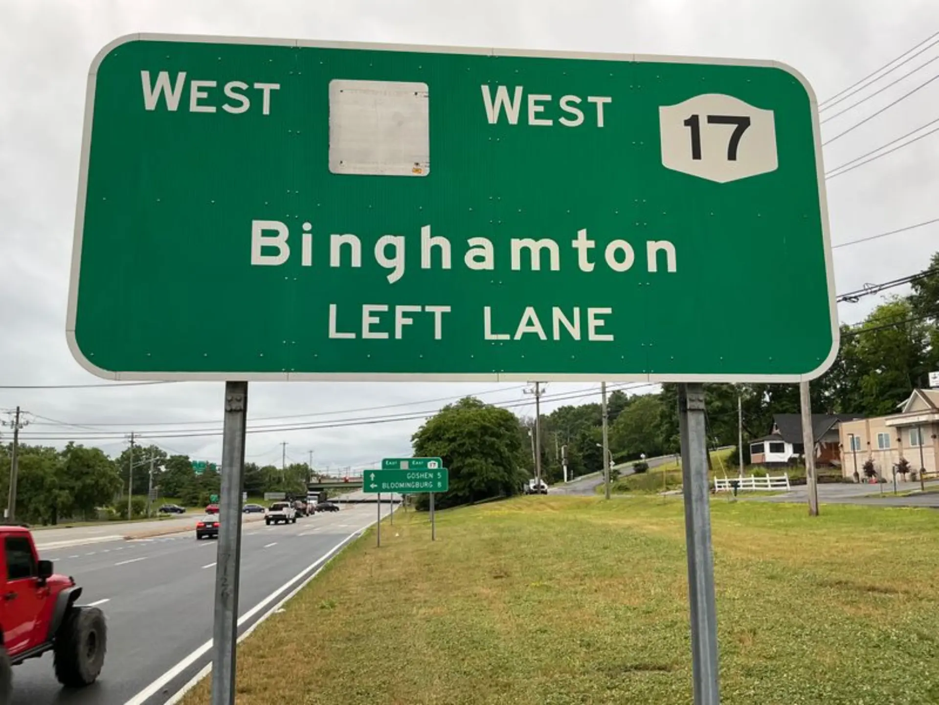 Large green overhead highway guide sign for West Route 17 to Binghamton, left lane