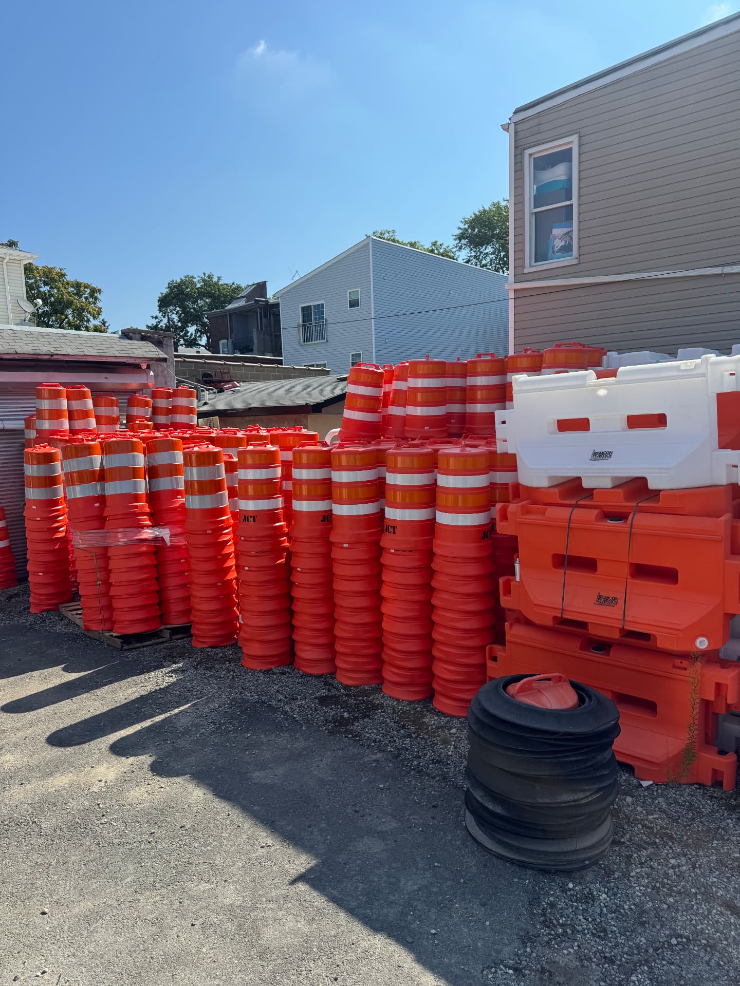 Stacks of orange traffic cones, drums and water-filled barriers staged in the Highway Traffic Control yard